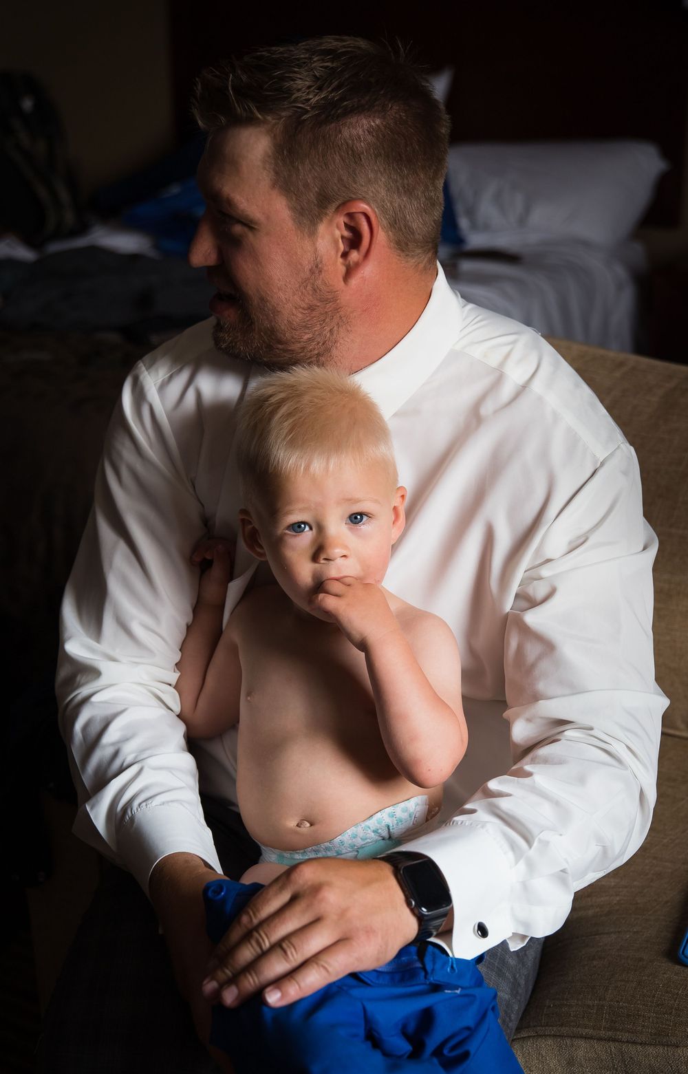 A tender moment captured in a series of black and white photos showing a parent holding a small child in a white shirt.