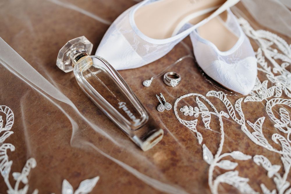 Delicate wedding accessories including perfume bottle and lace details.