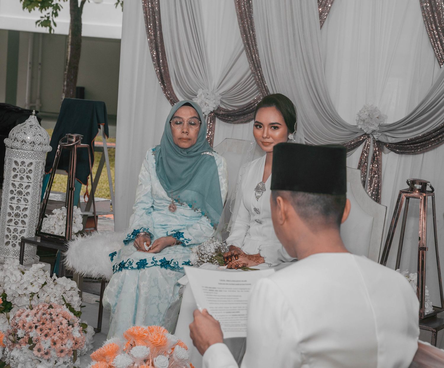 Traditional wedding ceremony with guests gathered around decorated table setting.