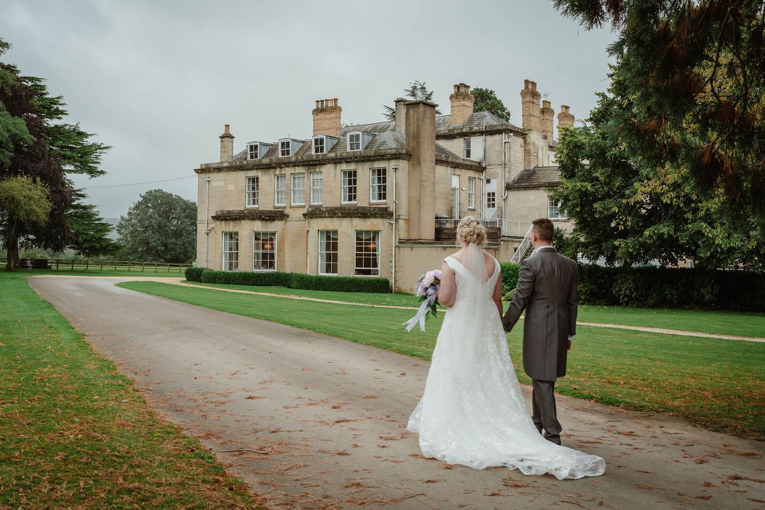 Eastington Park wedding photographer Zara Davis Photography couple walking on driveway to house gloucestershire cotswolds