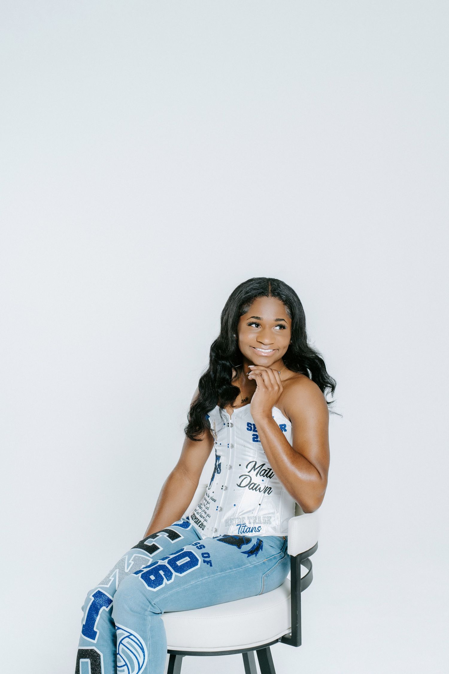 Three artistic black and white studio portraits of someone seated in casual attire with blue denim against white backdrop.