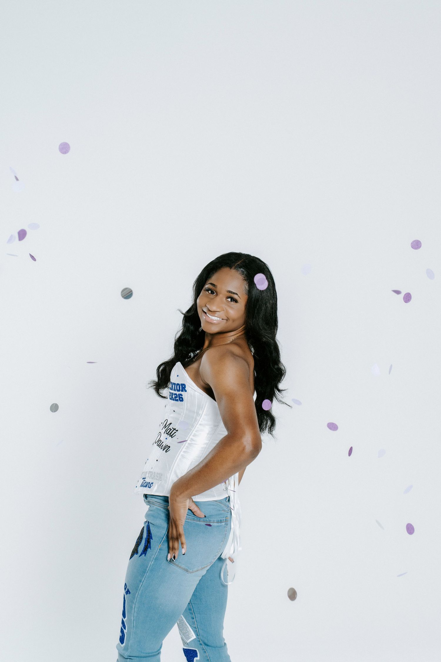Energetic studio portraits with light purple confetti against a white background.