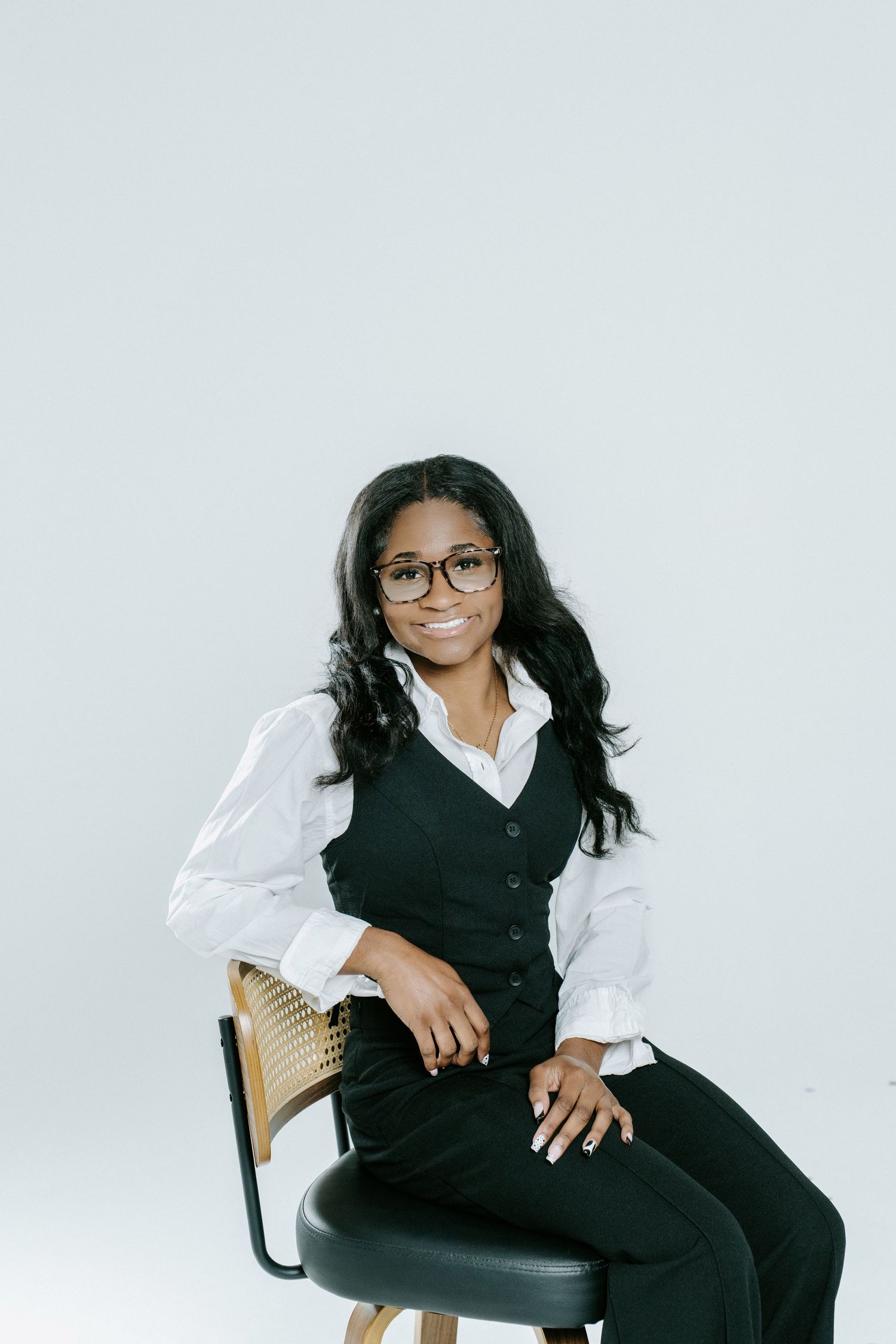 Professional studio portrait series with person in black vest and white shirt against light background.