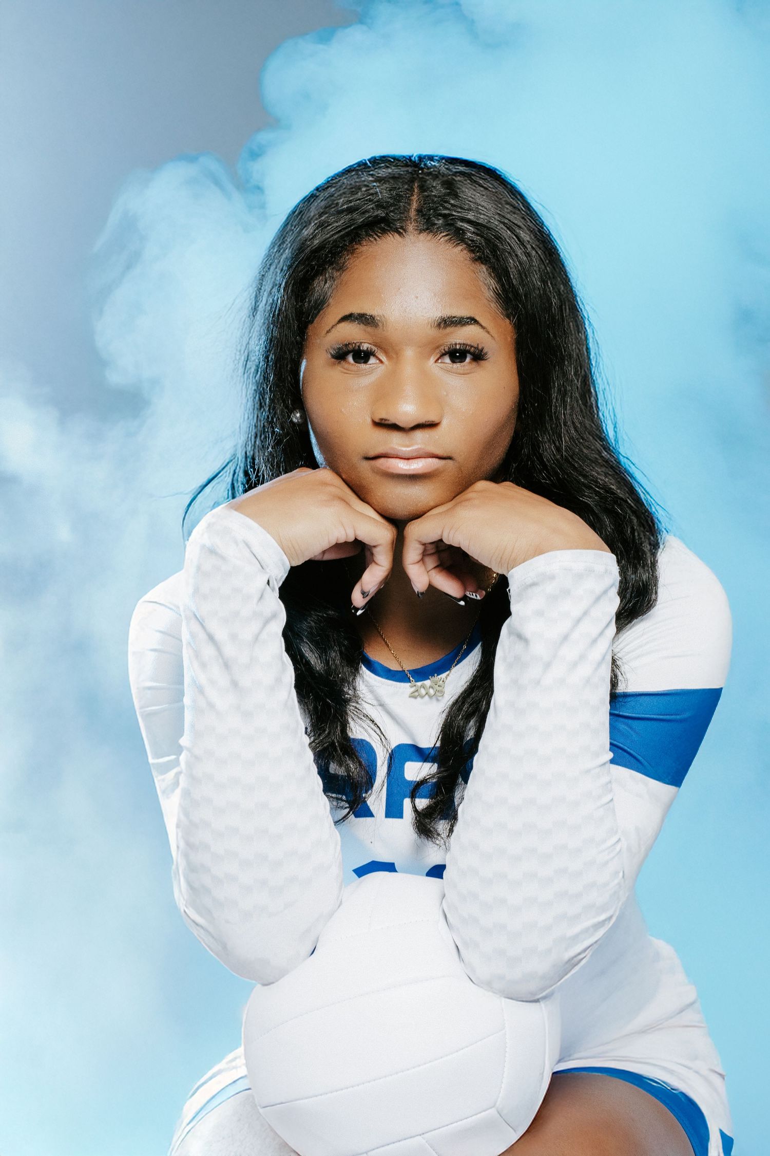 A series of four studio portraits with bright cloudy background showing someone in a white and blue outfit in different poses.