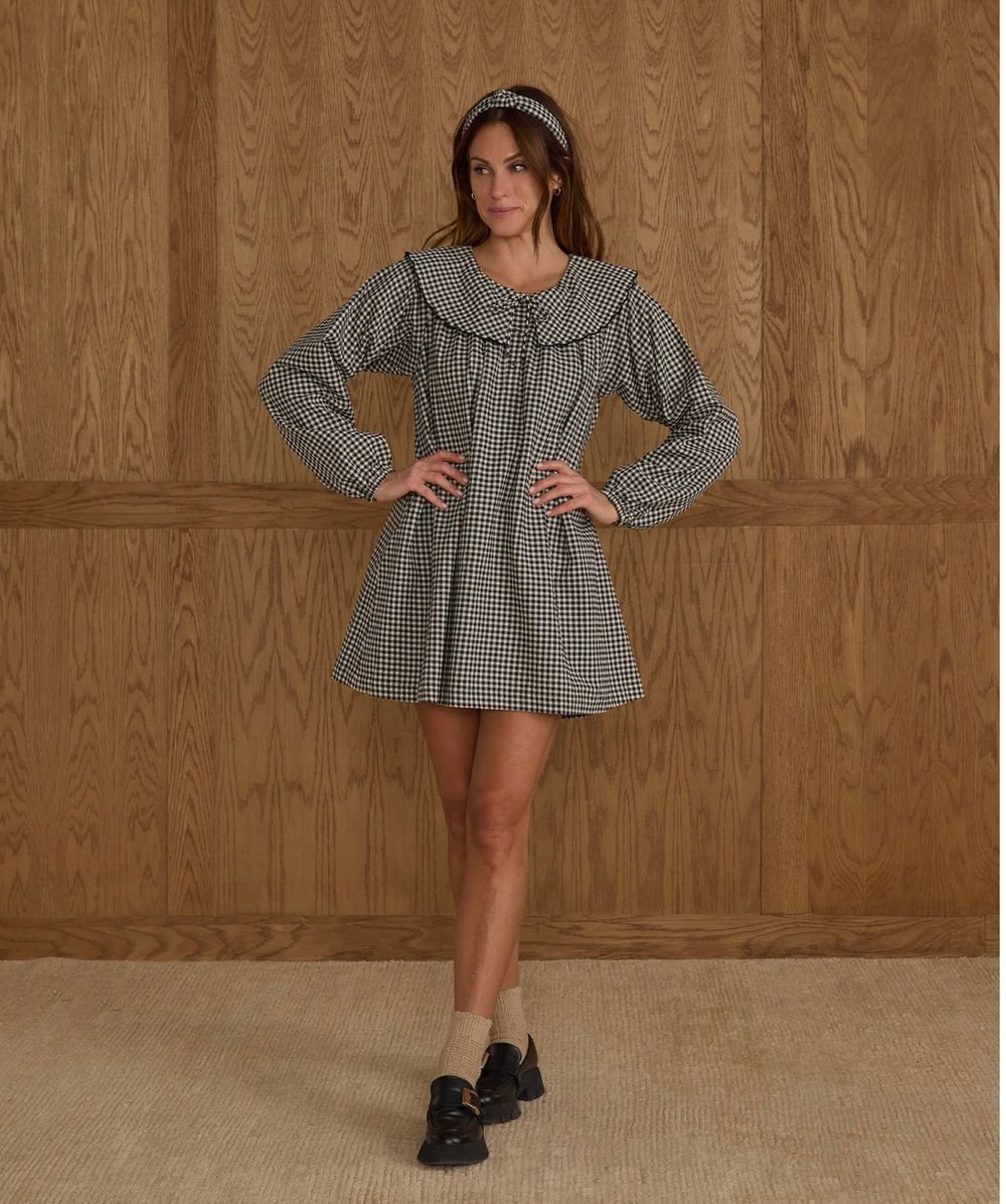 Model in gingham dress poses in multiple positions against wooden wall showcasing flowy sleeves and casual style.