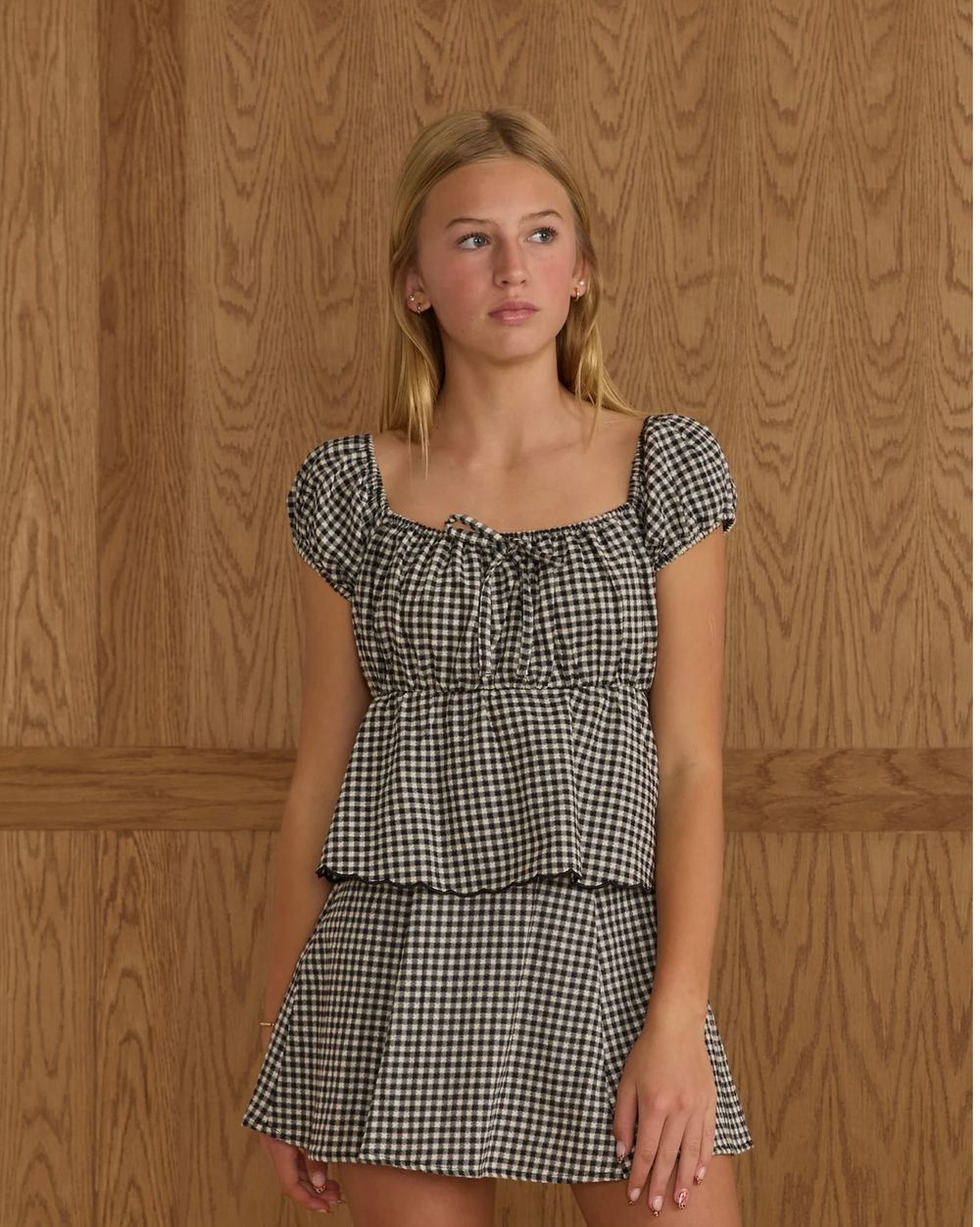 A model in black and white gingham ruched crop top shown from multiple angles against a wooden backdrop.