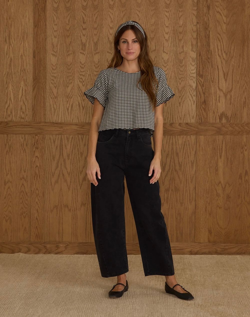Side by side photos showing different views of a gingham blouse paired with long black pants against a neutral wall.