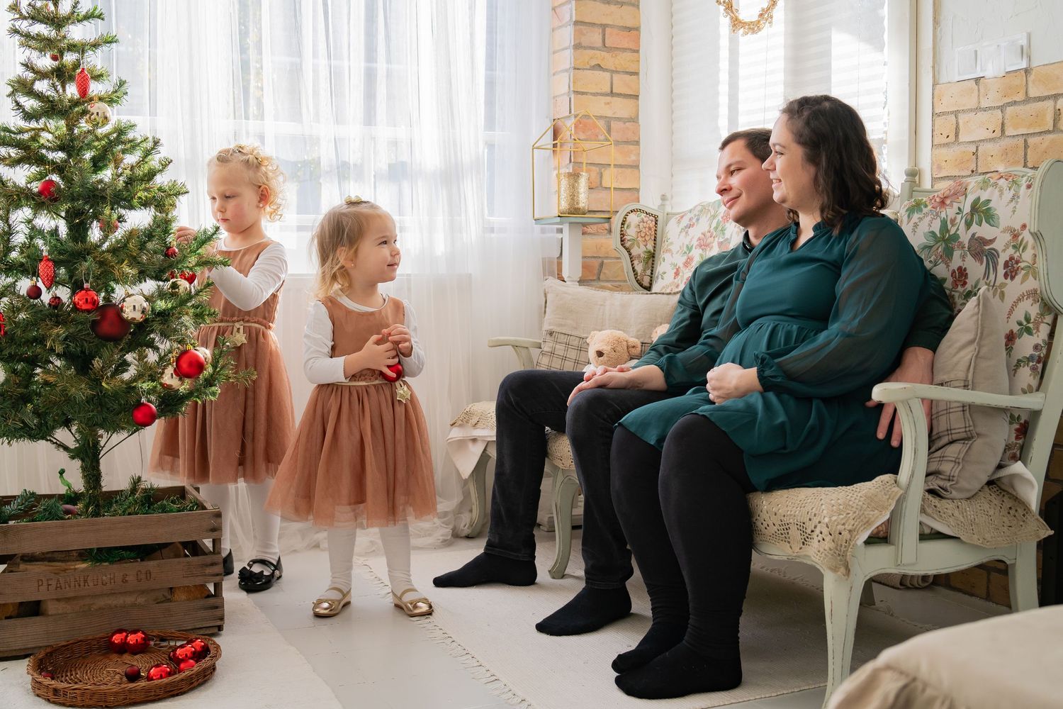 Feldíszített karácsonyfa áll a hangulatos nappali sarkában, ülőhelyekkel és ünnepi dekorációval.