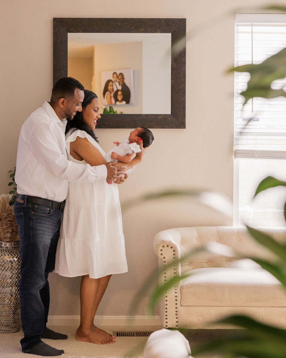 Couple in white and denim share intimate dance moment in minimalist home setting.