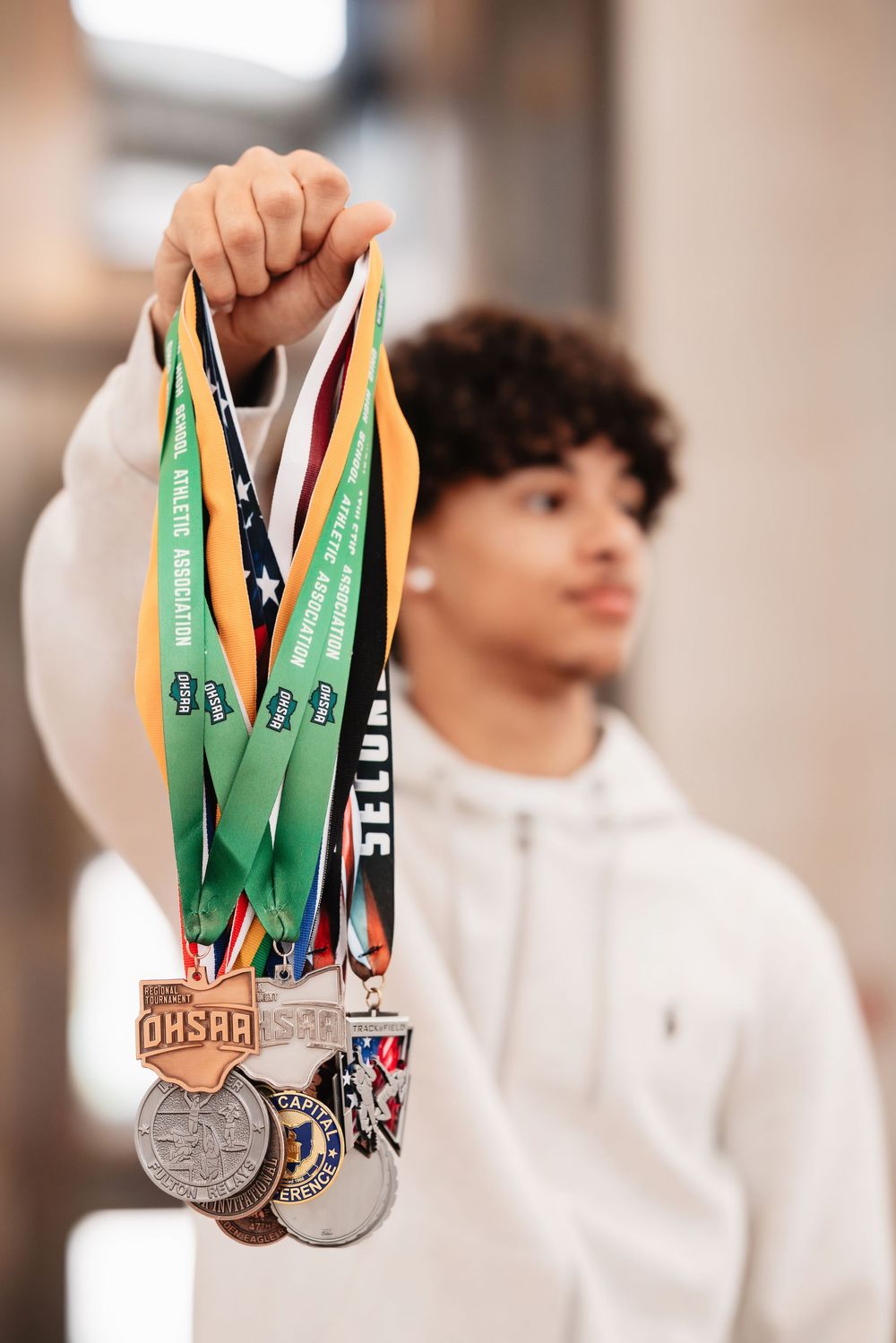 Collection of athletic medals and ribbons being displayed against a light background.