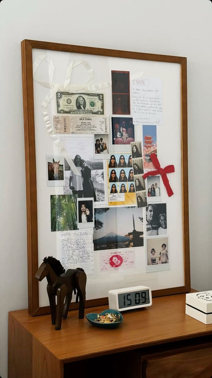 A wooden framed memory board displays photos, money, and mementos alongside a decorative horse figure and digital clock.