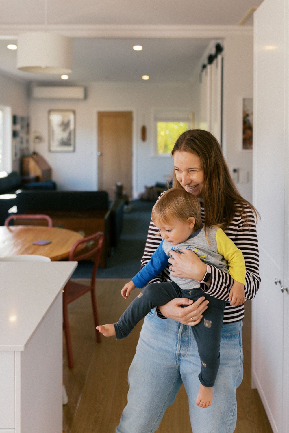 Parent and child playing together in a bright living room interior with joyful expressions.
