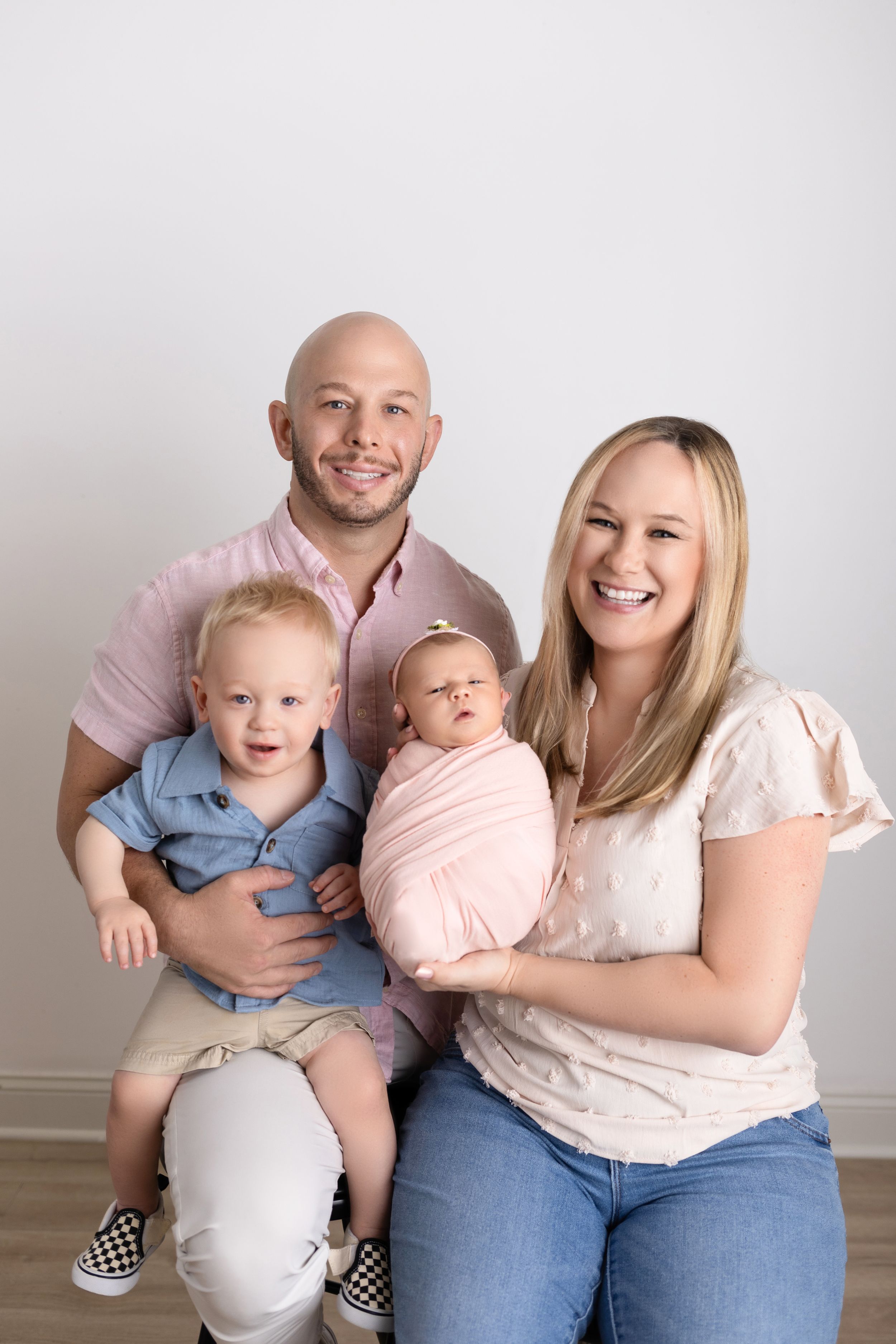 A family of three sits together against a white backdrop, captured in a series of candid lifestyle portraits.