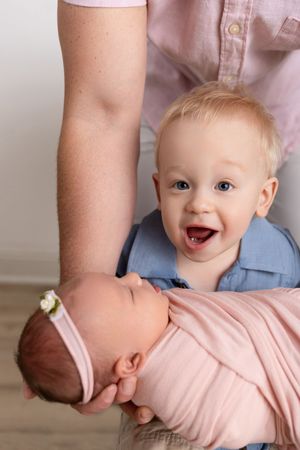 Series of closeup shots showing a baby in pink clothing making expressive faces while playing.