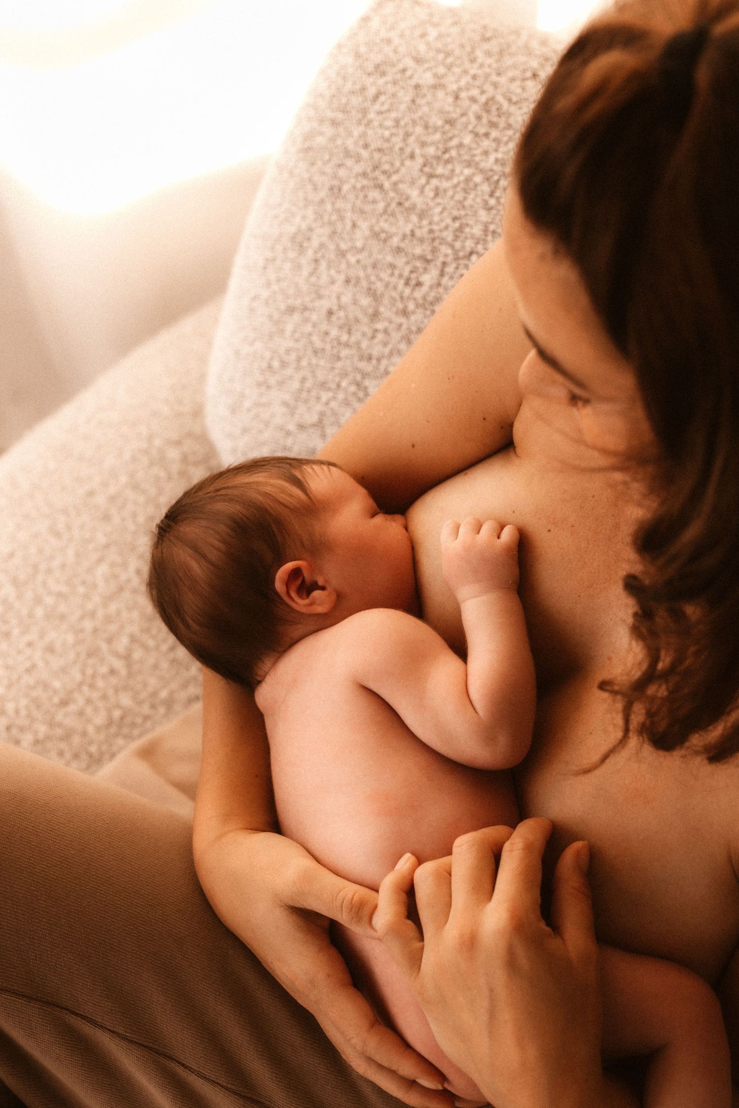 Intimate closeup in sepia tones in Javea  showing tender moment of breastfeeding between parent and newborn baby- Javea newborn photographer