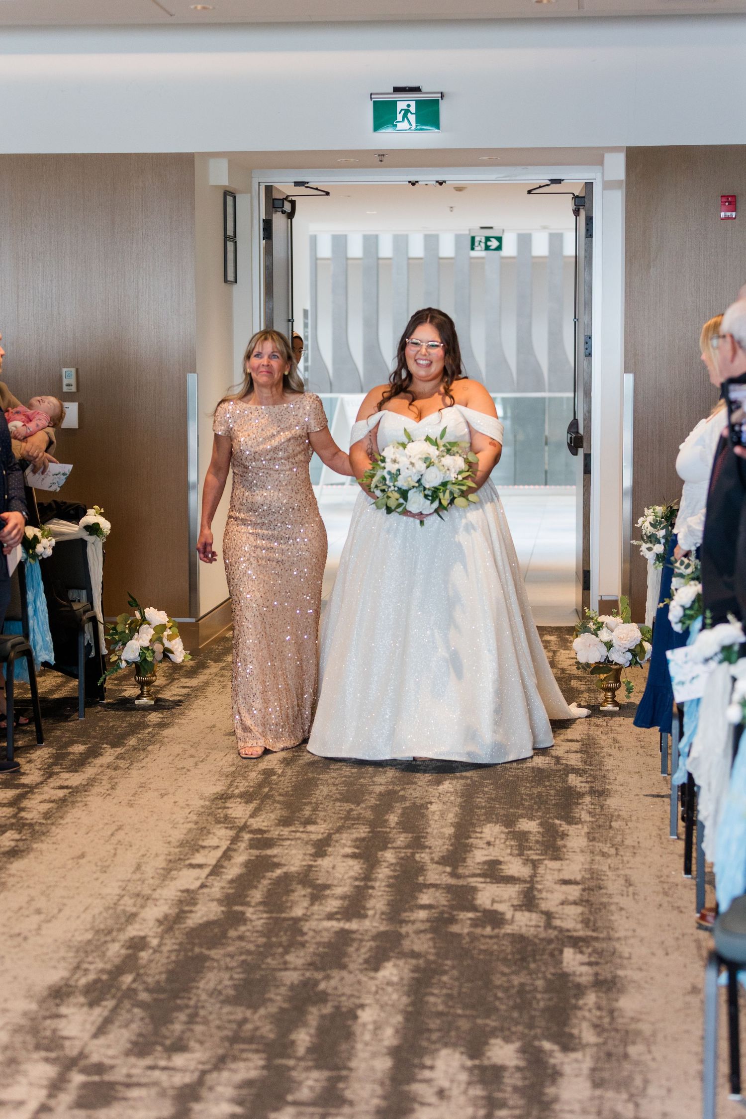 Wedding celebration with bridal party in sequined gold dresses and white gown dancing joyfully in reception venue.
