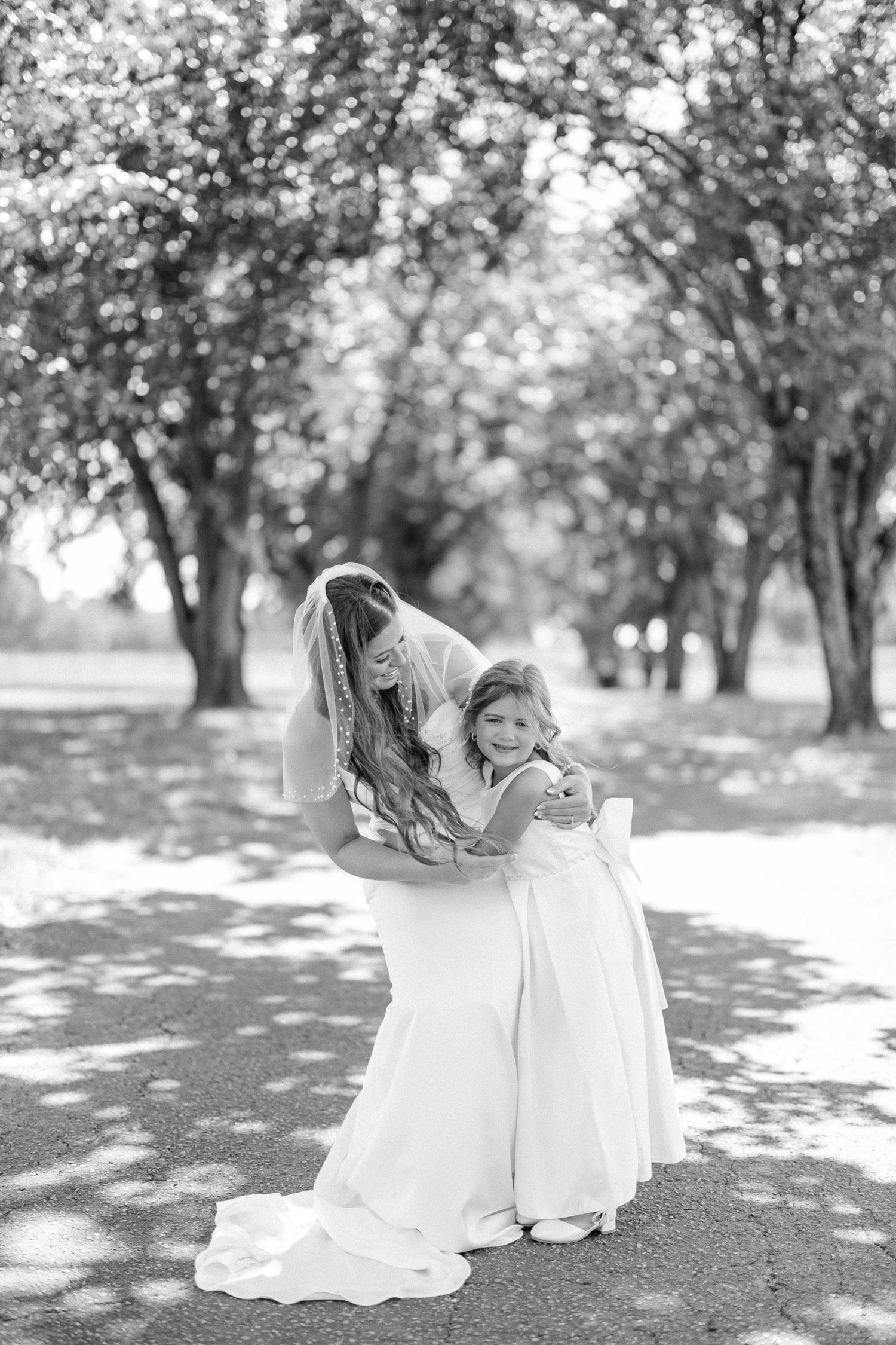 A graceful black and white photo sequence shows a figure in a flowing white dress spinning and twirling in a park setting.