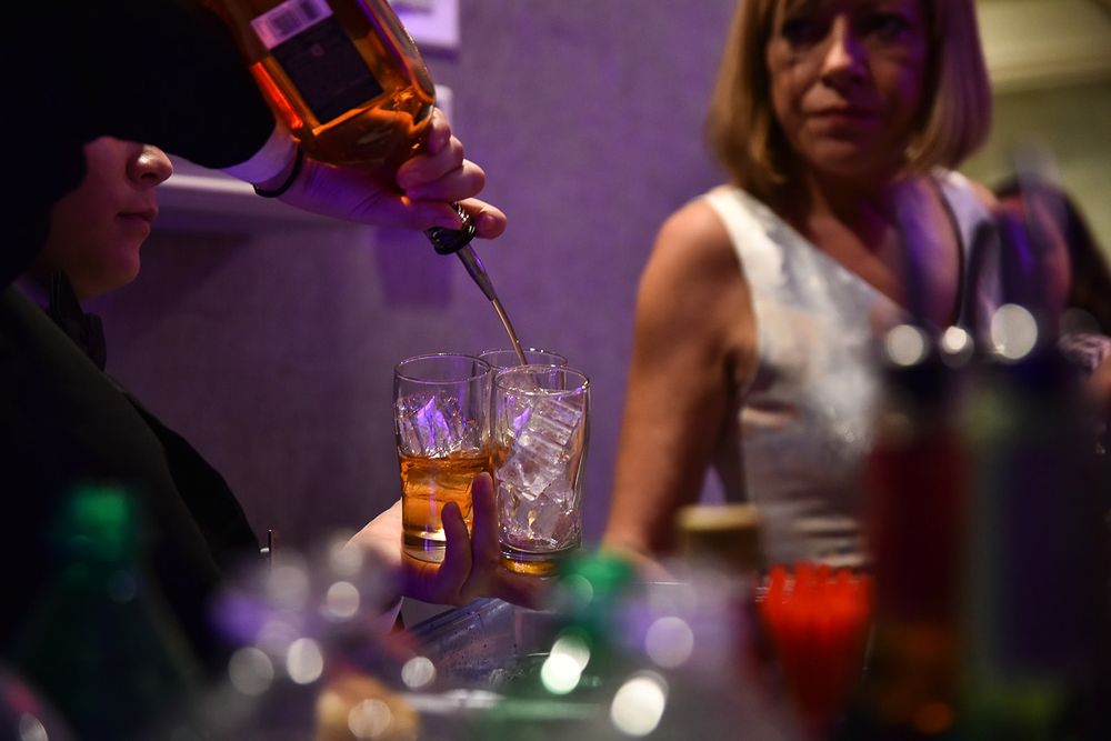 Close-up shots of cocktail glasses with colorful drinks under purple ambient lighting at an evening event.