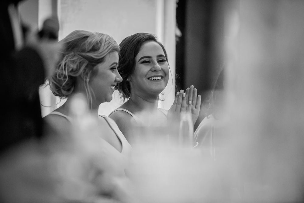 Black and white series of candid moments showing joyful reactions and laughter during an elegant event.