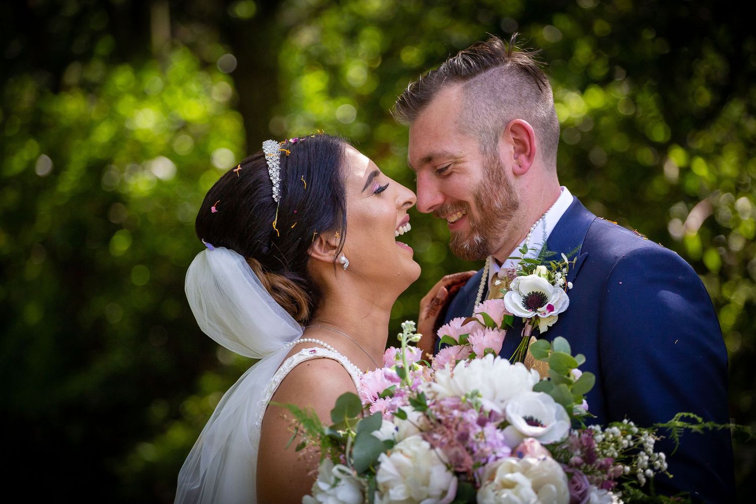 Romantic outdoor wedding portraits with natural greenery backdrop and floral bouquet.