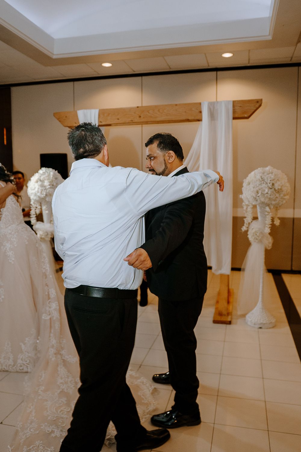 Multiple couples practice dance steps in formal attire in a mirrored ballroom studio setting.