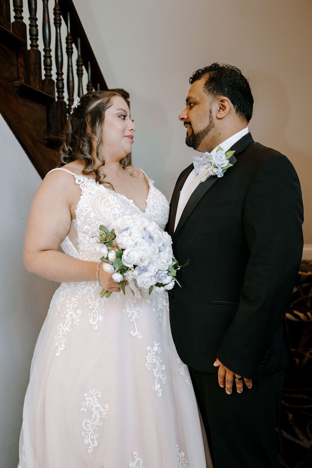 A romantic series of wedding photos showing a couple in white bridal gown and black suit by a staircase.