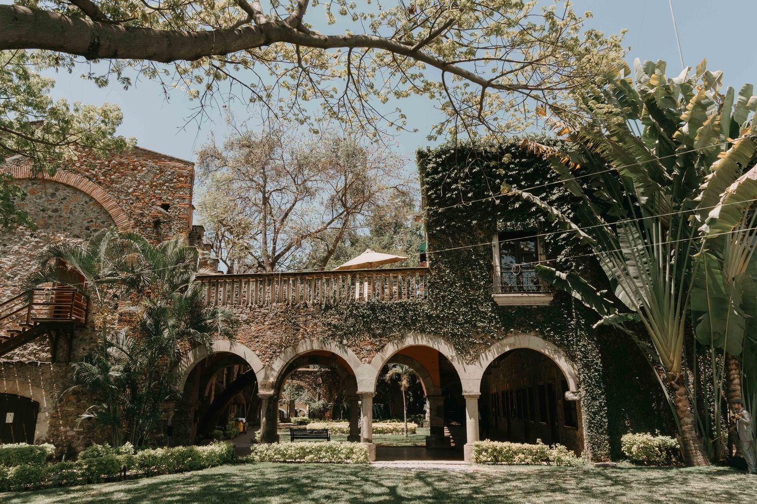 Elegant stone archways and landscaped gardens frame romantic wedding portraits.