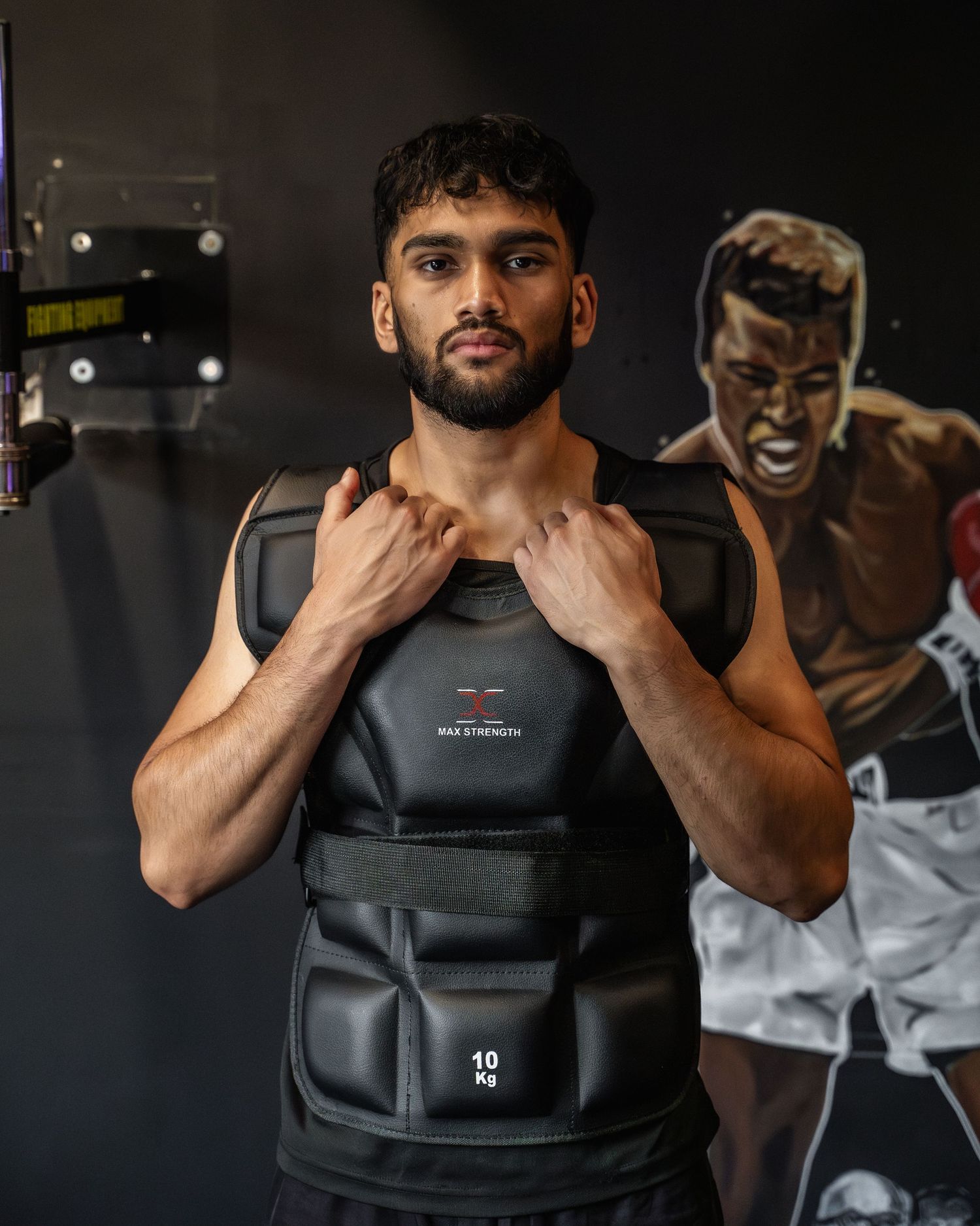Athletic figure wearing protective padded training vest in gym setting.
