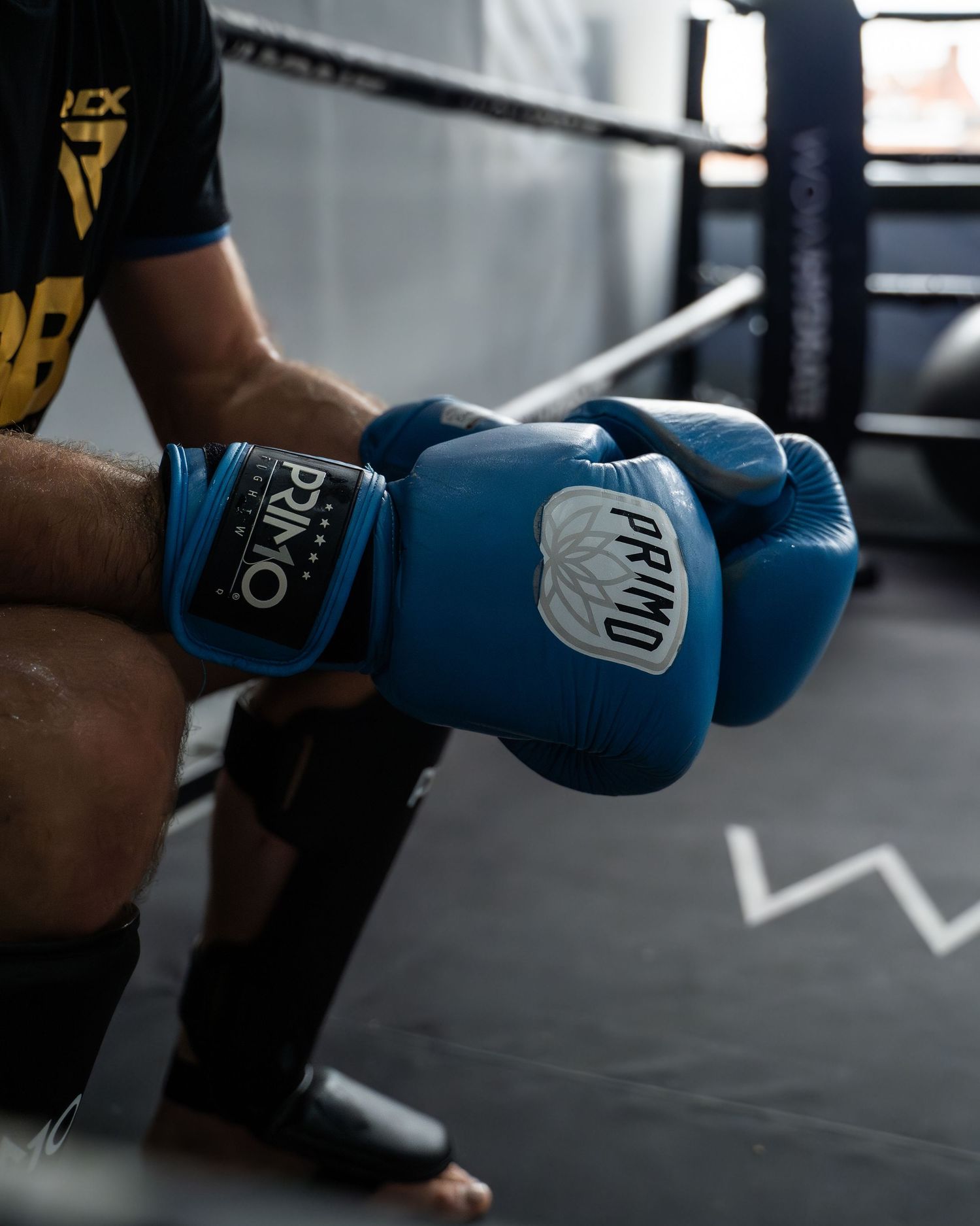 Close-up of bright blue boxing gloves against a dark gym background.