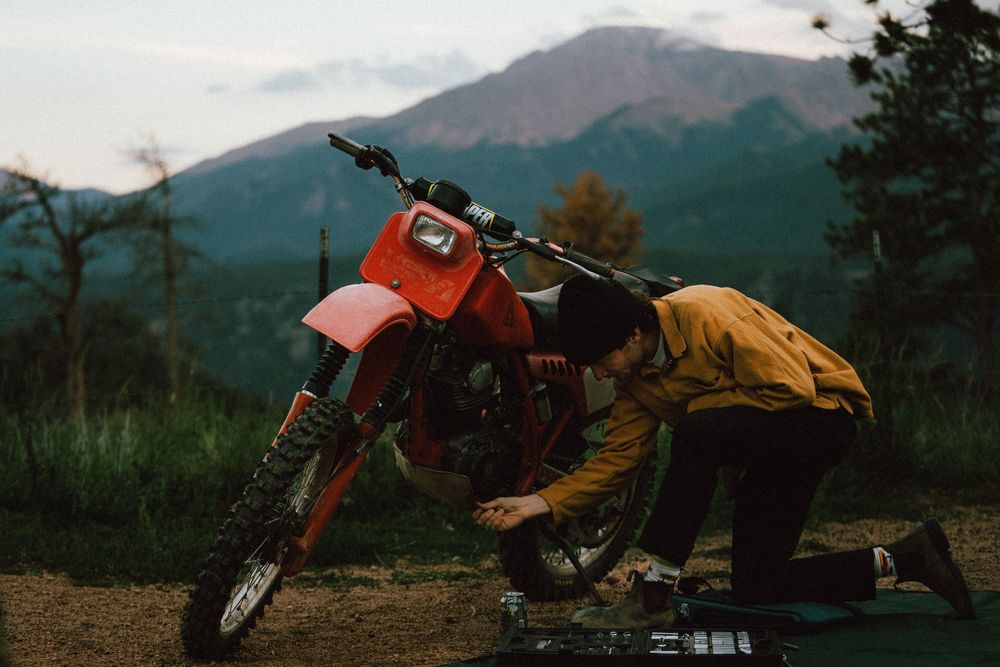 Mountain bikes parked against scenic mountain backdrop during sunset.