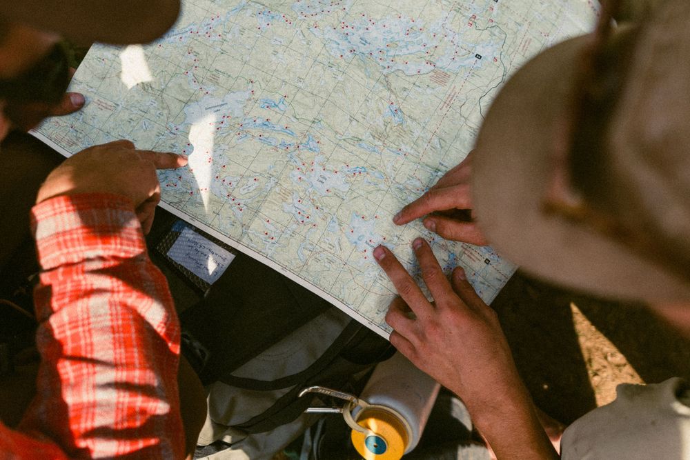 Group studying map and planning route during outdoor adventure.