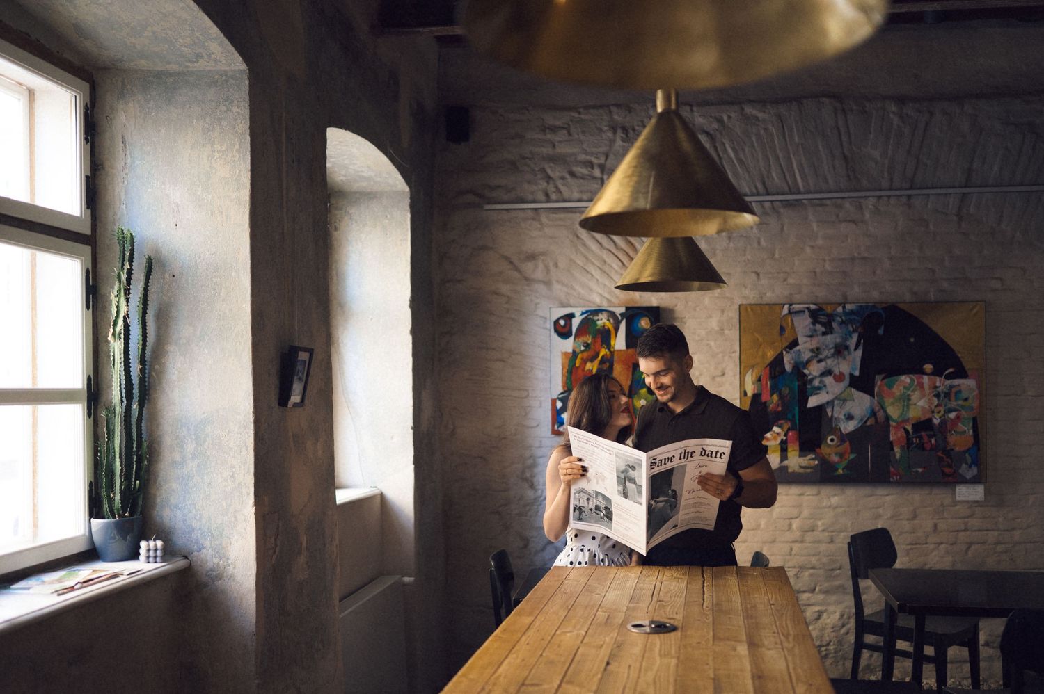 A panoramic view of a dimly lit room with vintage furniture and windows casting natural light across the space.