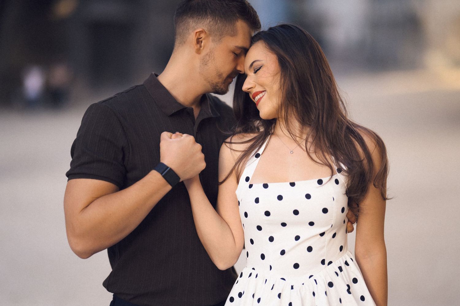 A couple shares an intimate moment together while wearing black and white polka dot outfits.