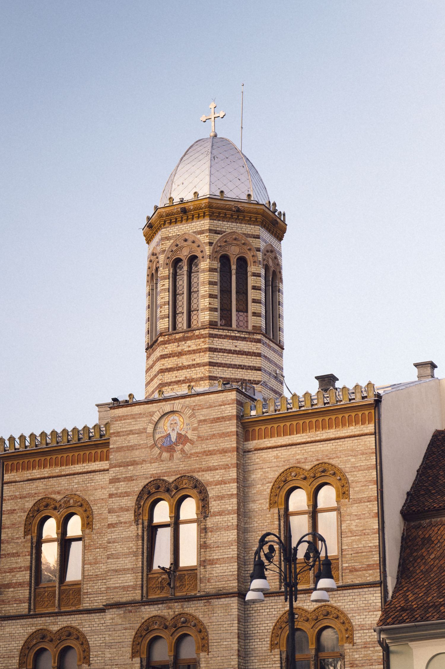 Ornate architectural detail of a historic church or cathedral with striped stone facade and twin domed towers.