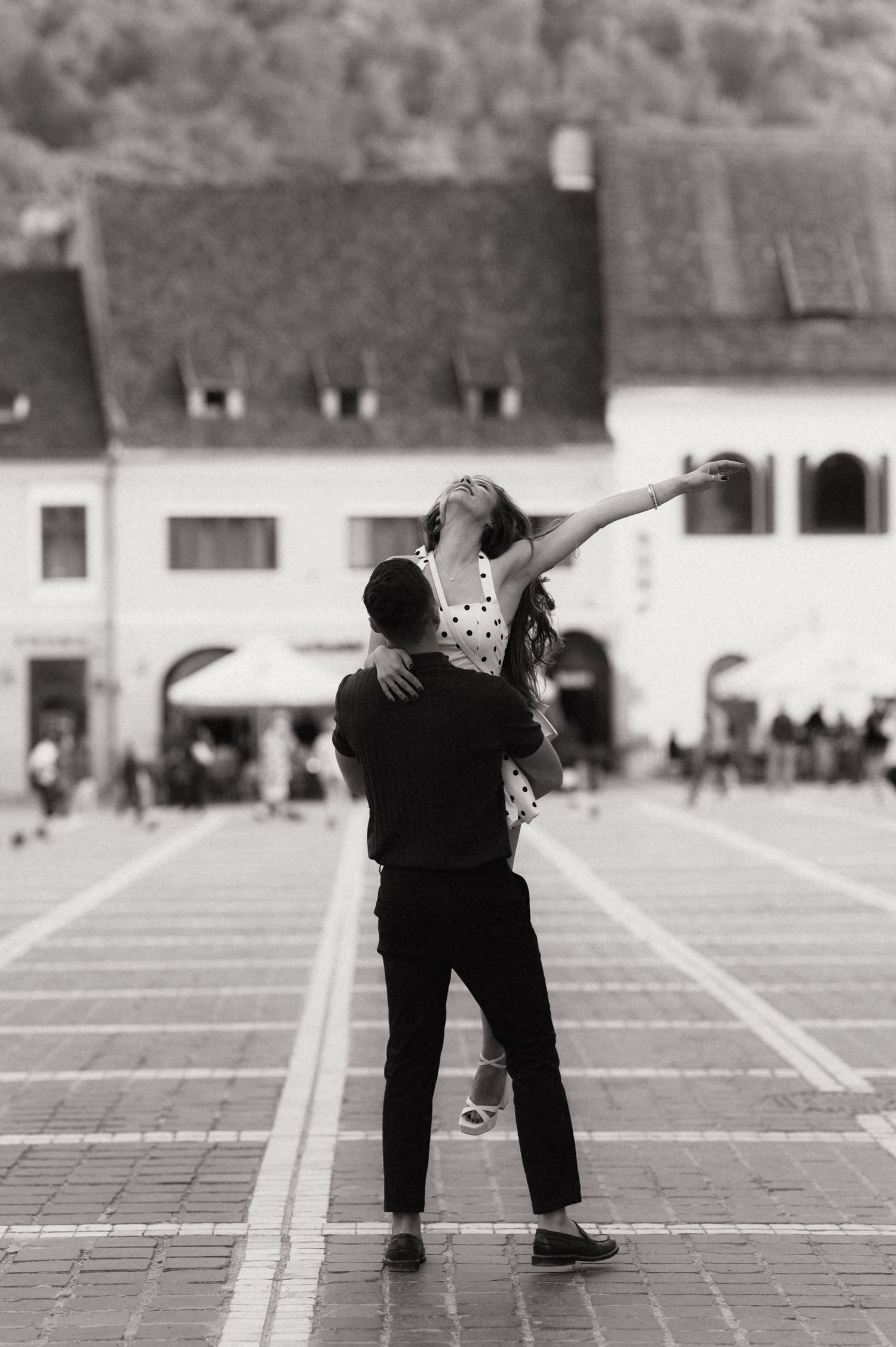 A black and white photo sequence shows two people dancing tango steps on a tiled plaza.