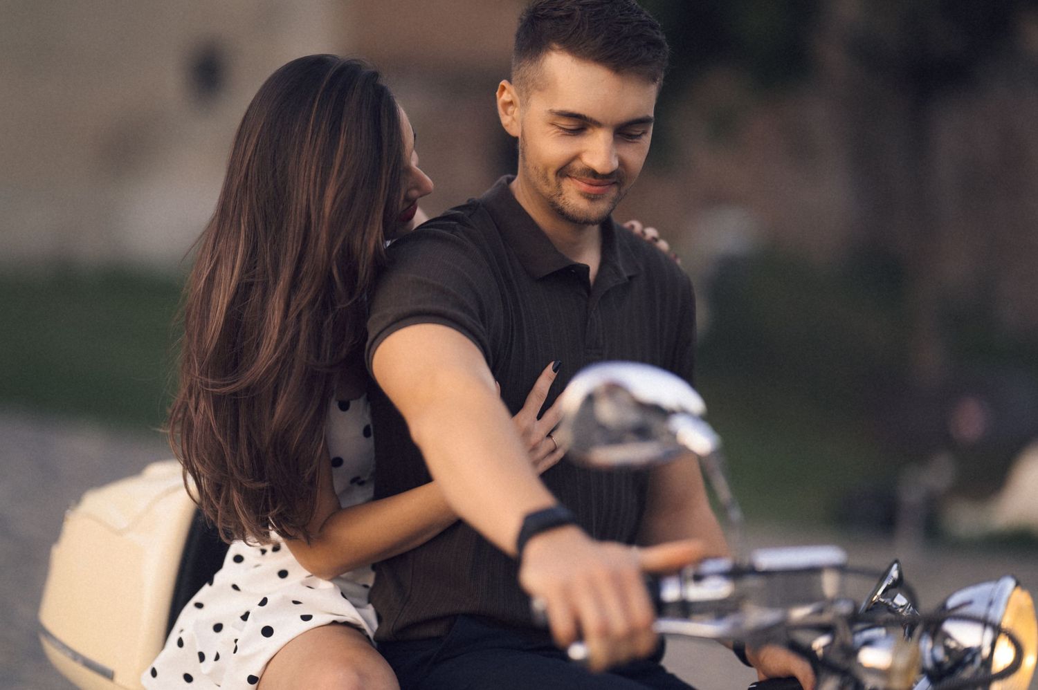 A couple rides together on a motorcycle through a scenic road on a sunny afternoon.