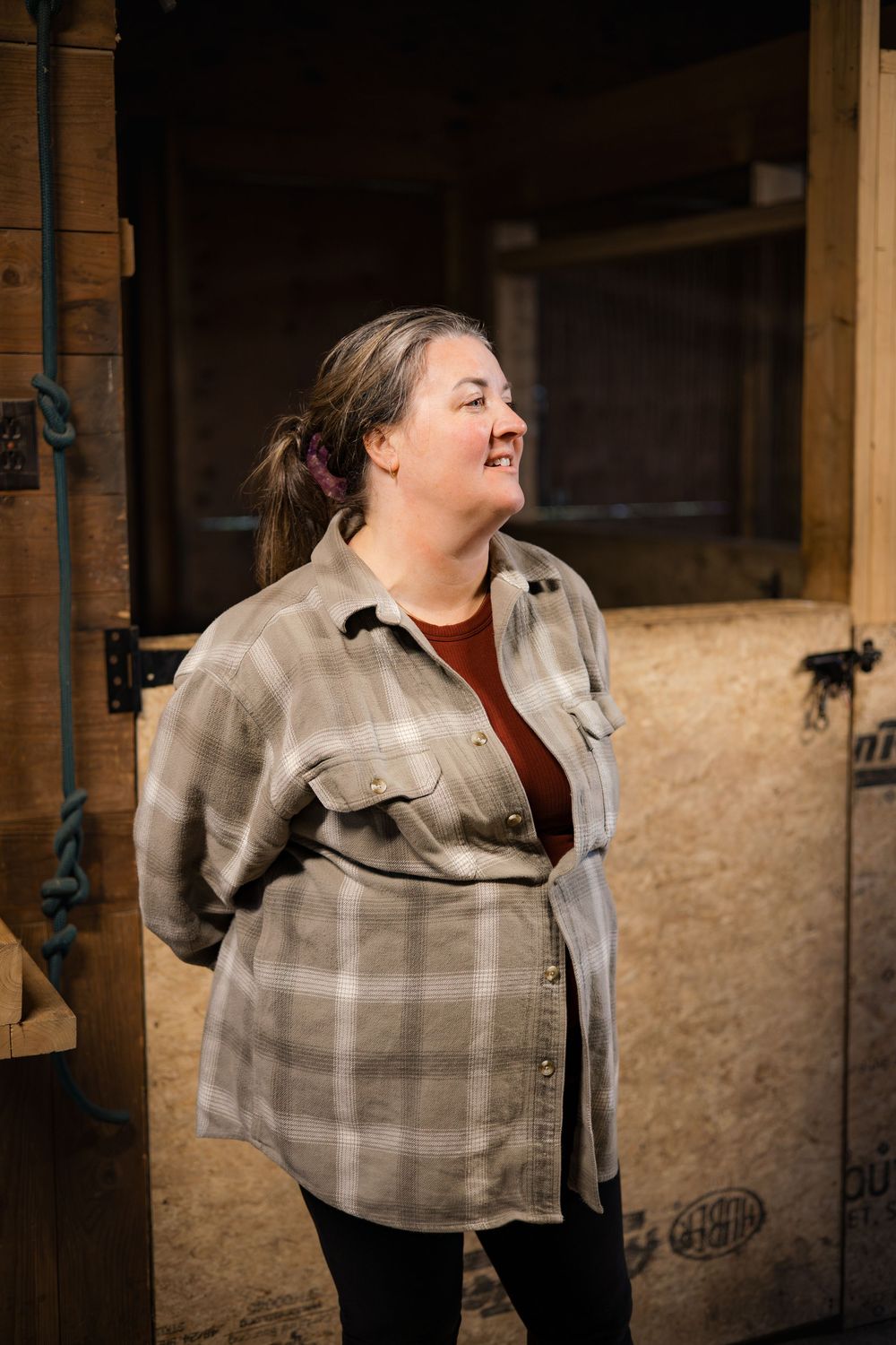 A series of four sequential photos showing a person in a plaid shirt laughing and moving against a rustic wall background.