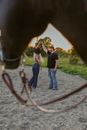People standing in a sandy field viewed through a rustic frame.