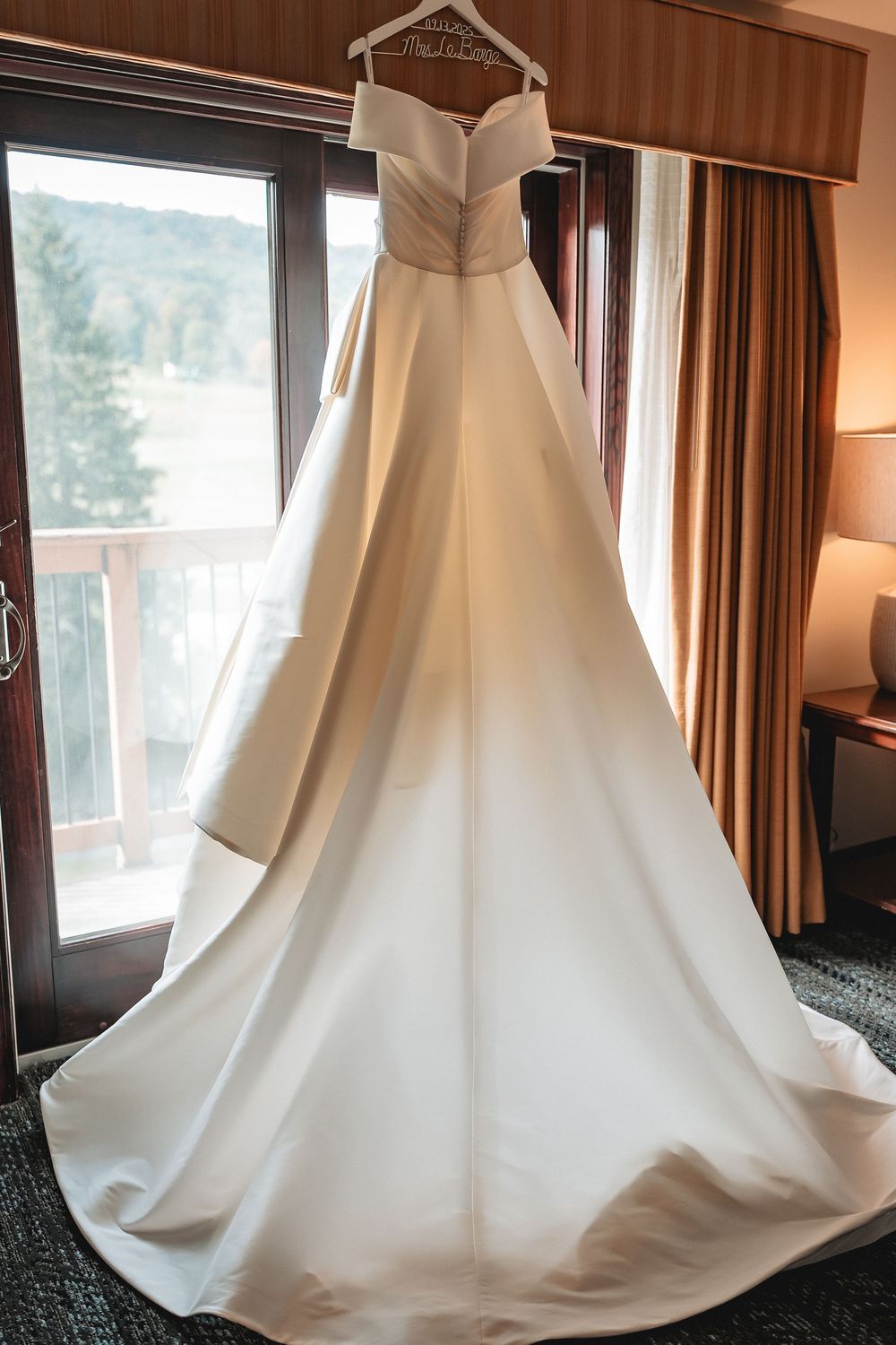 Four sequential photos of a flowing white wedding dress train displayed in a hotel room with brown curtains and window light.