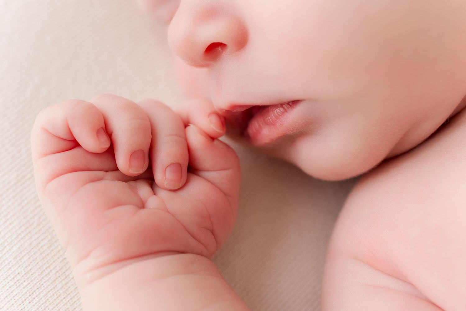 Close-up macro shots of newborn baby's delicate fingers and skin details.