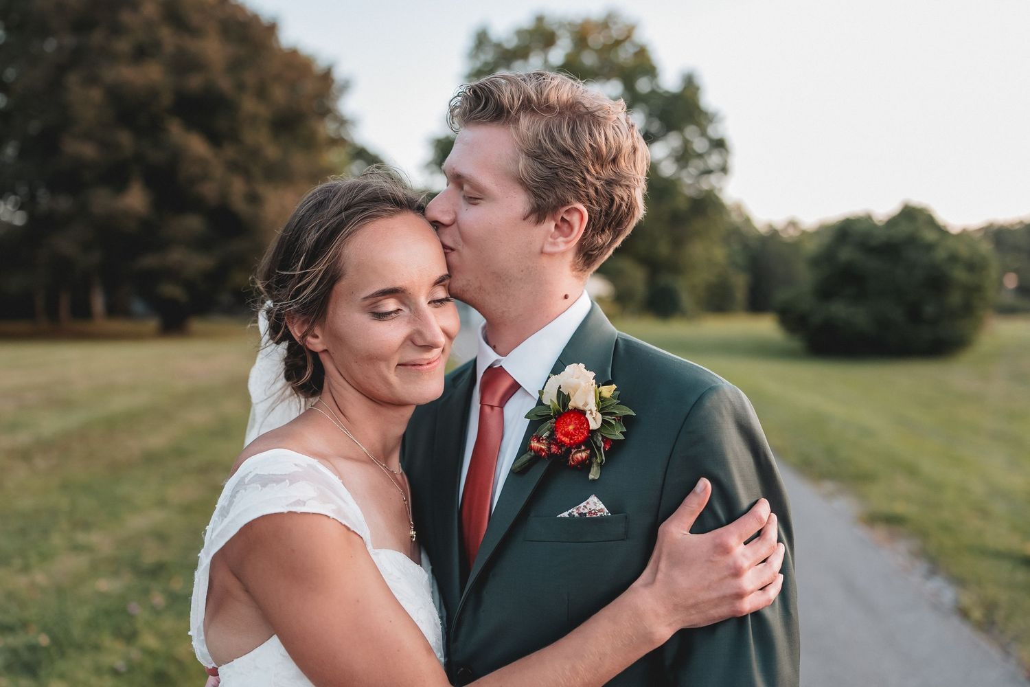A romantic close up photo of a couple about to kiss at their wedding outdoors.