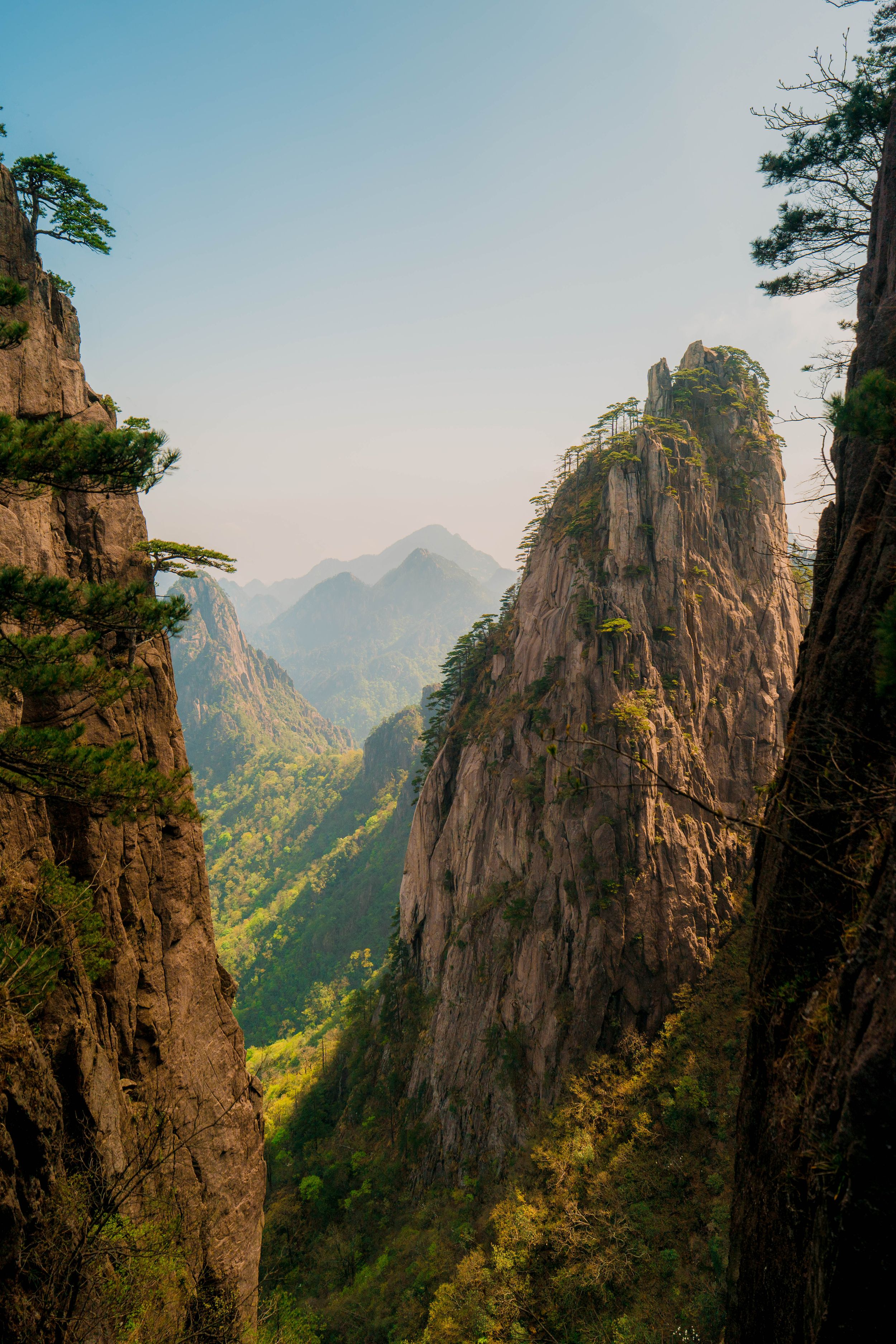 Stunning panorama of jagged mountain peaks and cliffs in Huangshan Yellow Mountains with misty valleys below.