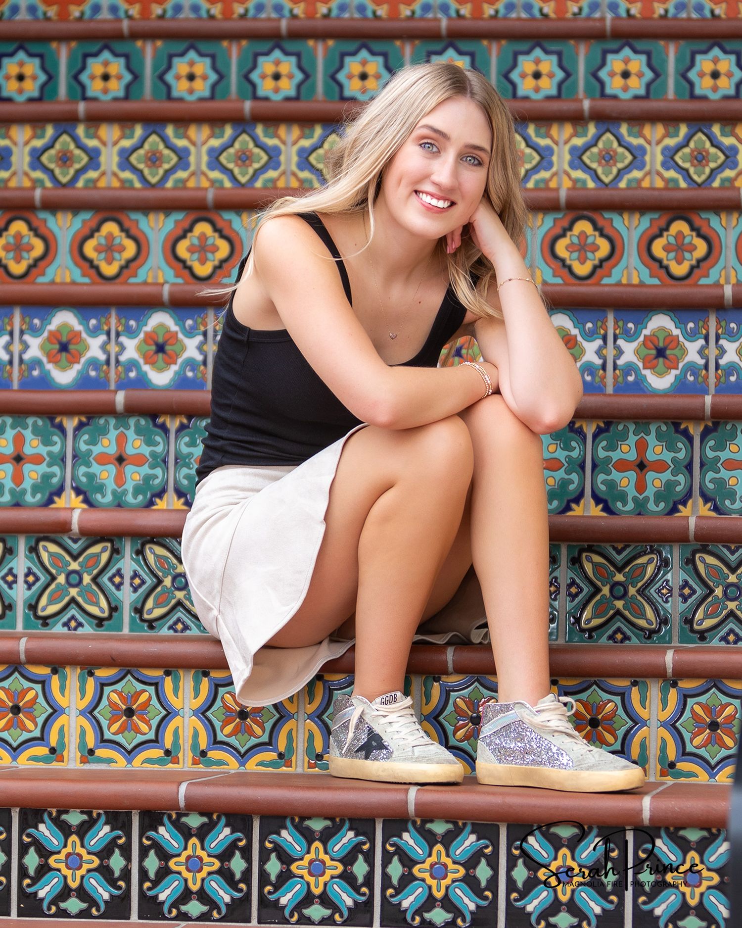 A casual outdoor photoshoot on colorful mosaic steps with vibrant geometric patterns and decorative tilework.