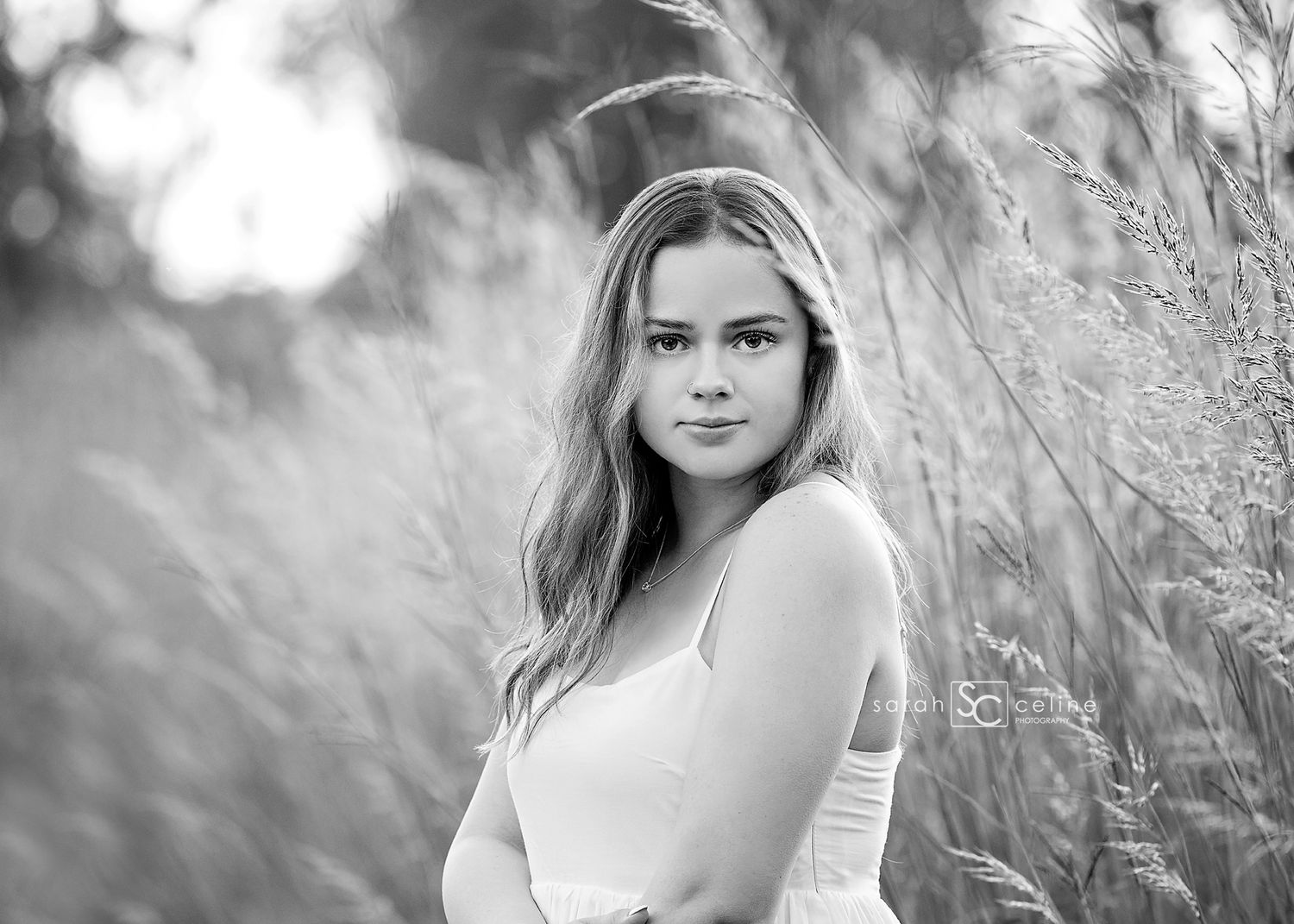 A series of black and white outdoor portrait photographs taken in a field of tall grass and wildflowers.
