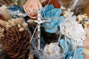 Rustic wedding decorations featuring pinecones, lace, and turquoise and peach floral accents arranged in vintage style.