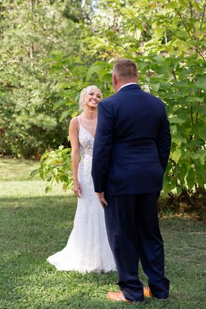 Emotional wedding first look sequence photographed in natural outdoor setting.