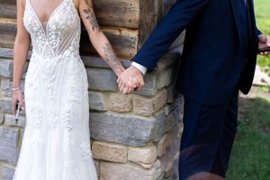 Romantic first look sequence photographed by rustic cabin exterior.