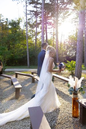 Sunset wedding photography session in pine forest with golden light streaming through trees.