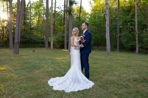 Elegant outdoor wedding photography session with tall pine trees in the background during golden hour.