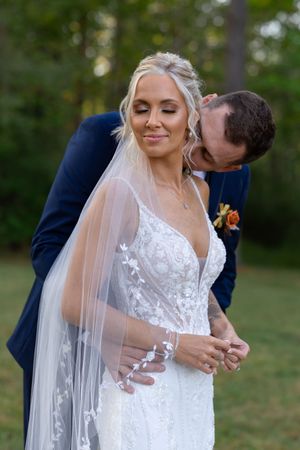 Detail shots of bride's lace wedding dress and flowing veil in natural outdoor lighting.